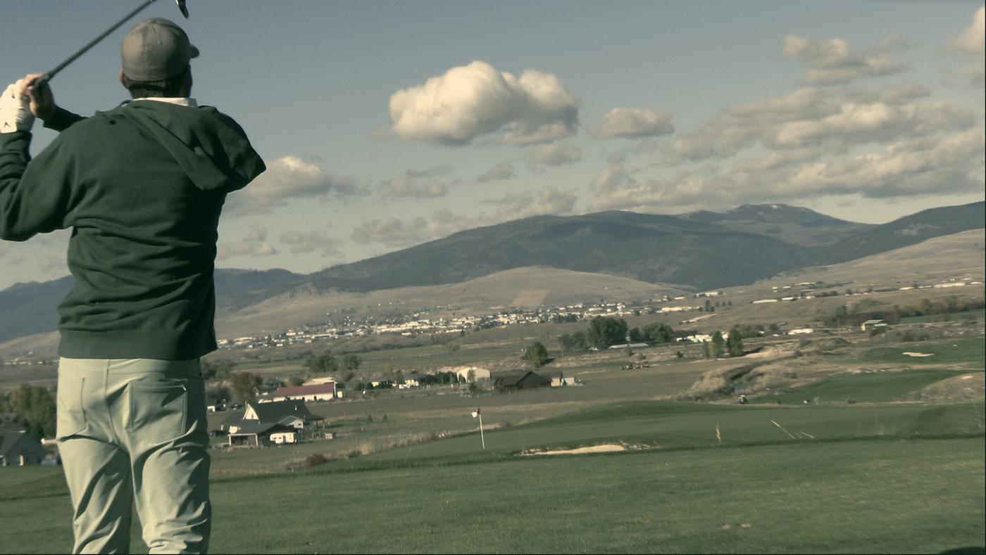 Tee shot over the Missoula valley, mountains behind